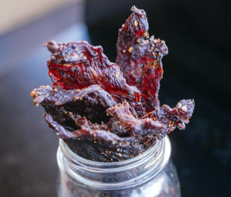 Tranches de beef jerky qui tiennent verticalement comme un bouquet de fleurs dans une jarre en verre Mason Jars