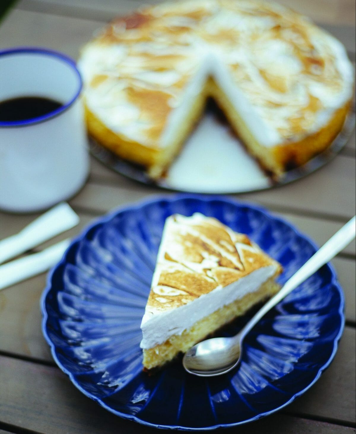 Une part de Tarte au citron meringuée dans une assiette bleue rétro.