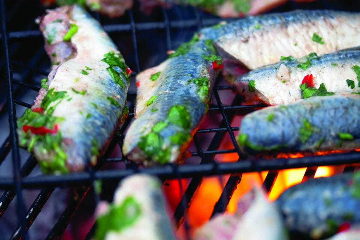 des filets de sardines marinés en train de griller au-dessus des flammes